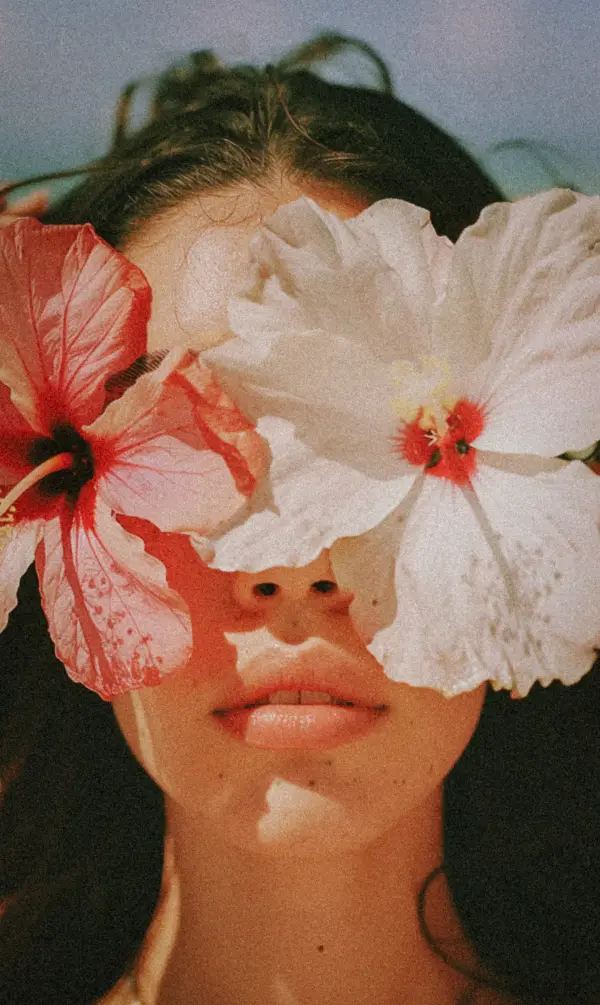 A portrait framed by hibiscus flowers